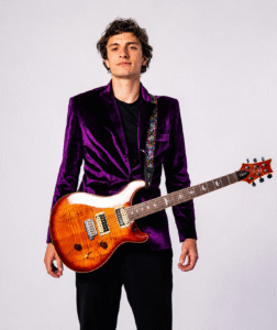 Malikhai Walton holding an electric guitar during a professional studio portrait for guitar, piano, bass, and ukulele lessons in San Diego.